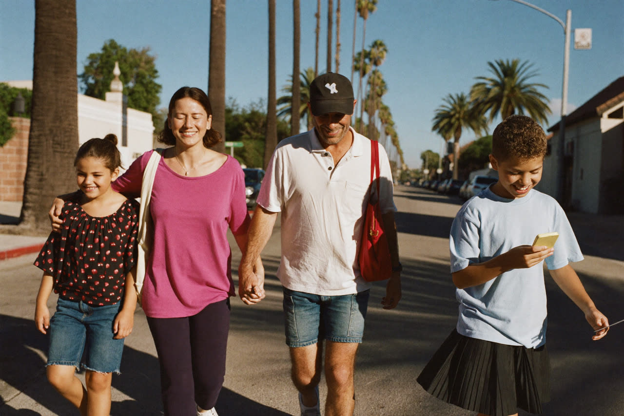 A family of four walking together along a sunny Santa Barbara street